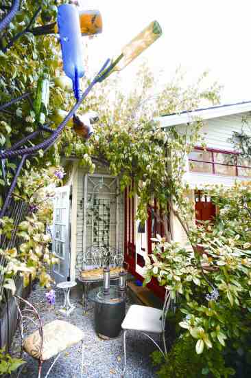 Alma styles small corners of her house and garden as their own distinct pocket spaces. Here, a small shady retreat is nestled into the far side of her front porch—replete with furnishings, art and plantings.